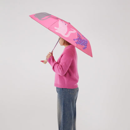 Person holding a pink umbrella with a cat pattern on a plain background