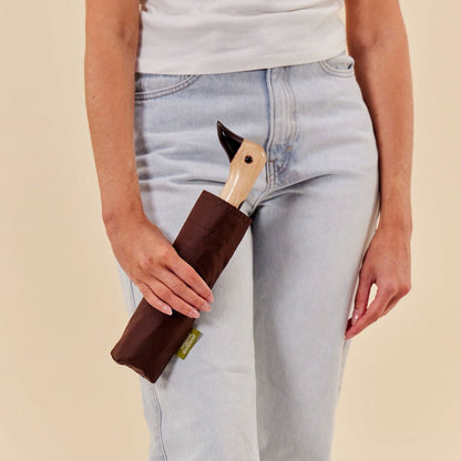 A persona holding the brown compact duck umbrella