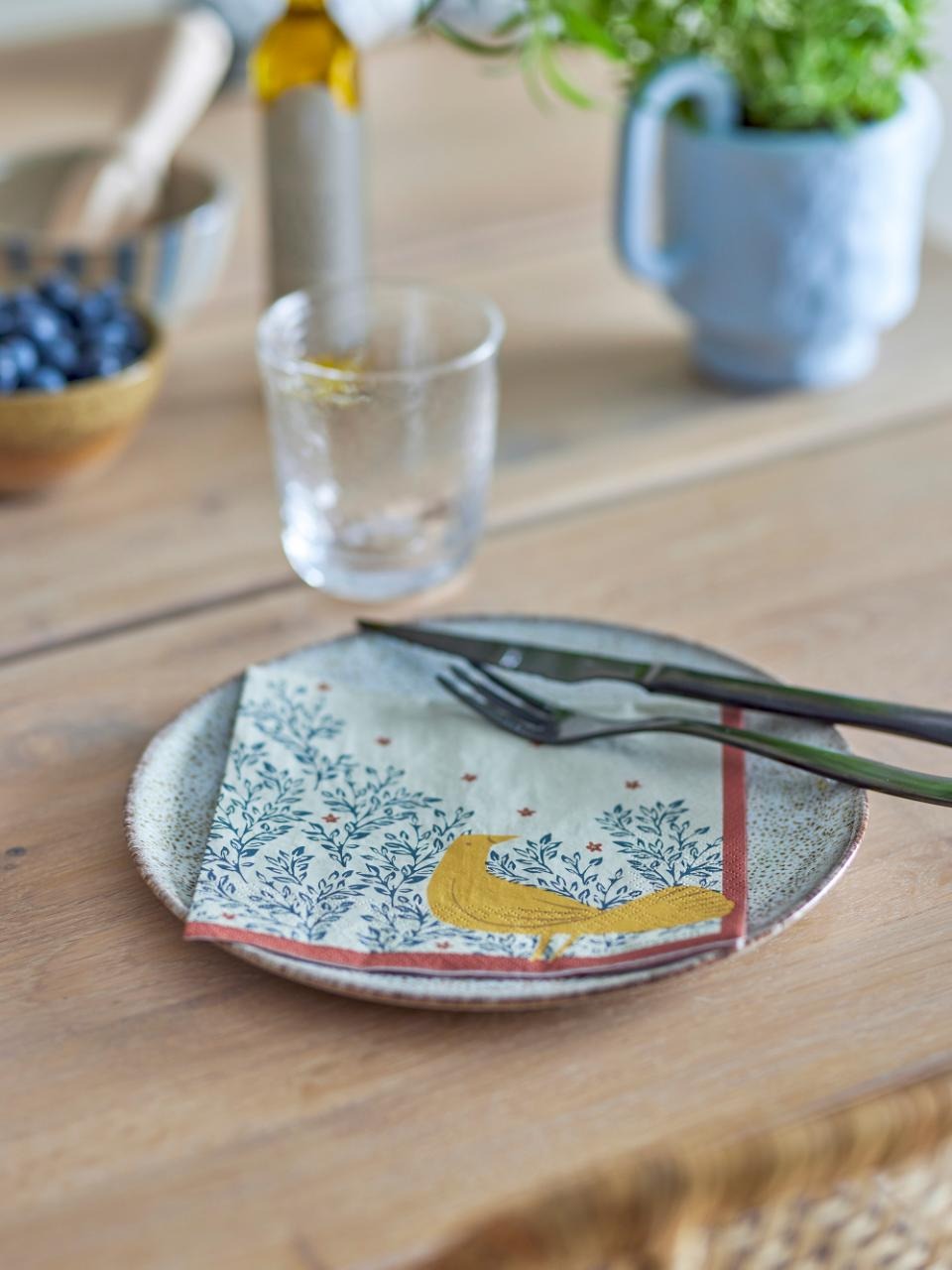 Ceramic plate with a decorative design on a wooden table and the hezha napkin