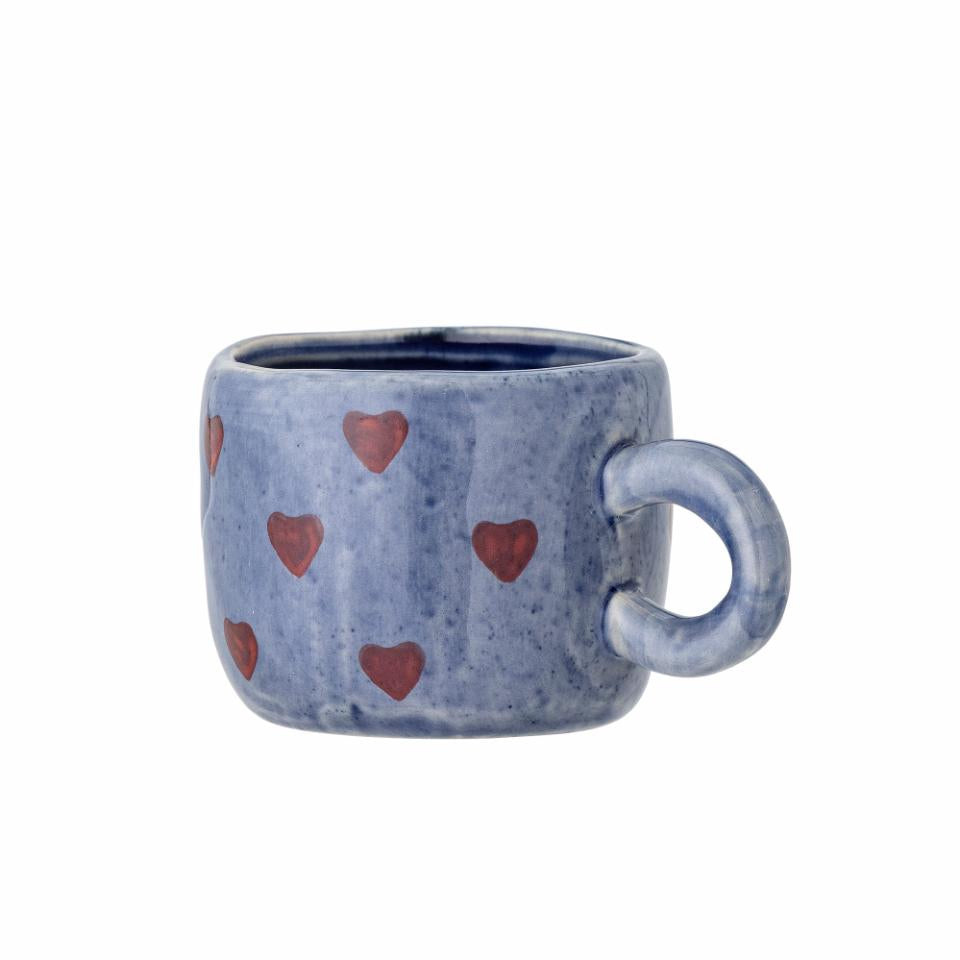 Blue ceramic mug with red heart patterns on a white background